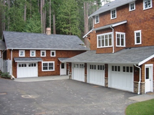 Four Custom Carriage House Garage Doors.  A Swing Carriage Door, or hinged carraige door, for the real carriage door garage on the left.  Three custom carriage style garage doors for the vintage garage on the right.